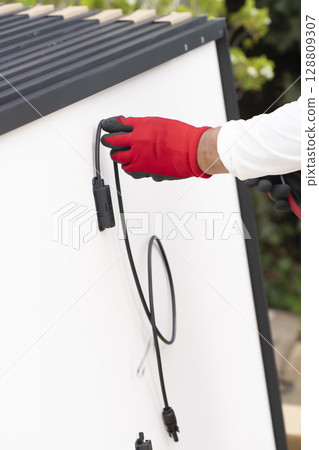 Solar panel wiring work for installing solar panels on the roof of a house Solar panel wiring work for installing solar panels on the roof of a house 128809307