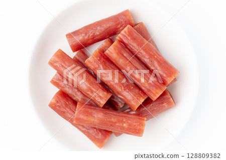 Dry sausage (Kalpas) on a plate on a white background Dry sausage (Kalpas) on a plate on a white background 128809382
