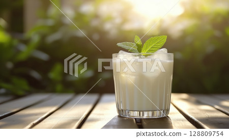 Refreshing mint cocktail in a glass with ice on a wooden table Refreshing mint cocktail in a glass with ice on a wooden table 128809754