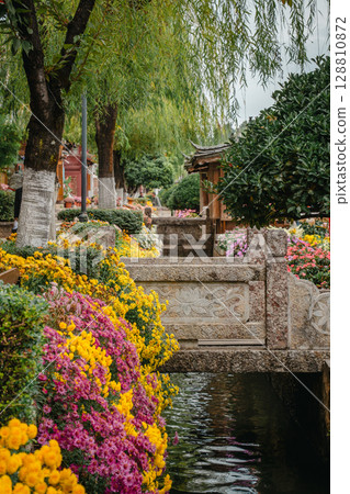 Stone bridge over flower-lined canal in Lijiang Old Town, China Stone bridge over flower-lined canal in Lijiang Old Town, China 128810872