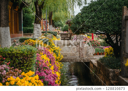 Stone bridge over flower-lined canal in Lijiang Old Town, China Stone bridge over flower-lined canal in Lijiang Old Town, China 128810873