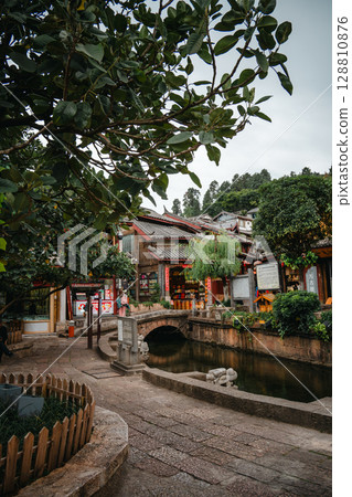 Serene canal view in Lijiang Old Town with trees and stone paths Serene canal view in Lijiang Old Town with trees and stone paths 128810876