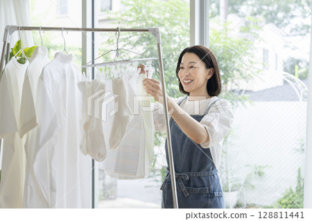 一位 50 多歲的女士正在晾衣服 一位 50 多歲的女士正在晾衣服 128811441