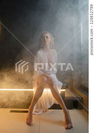 Relaxing moment for a woman in a spa sauna with soothing steam surrounding her Relaxing moment for a woman in a spa sauna with soothing steam surrounding her 128812789