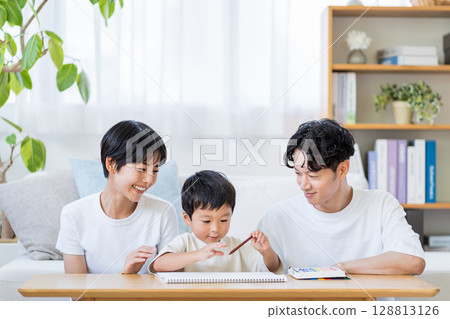 A child drawing while his parents watch. A child drawing while his parents watch. 128813126
