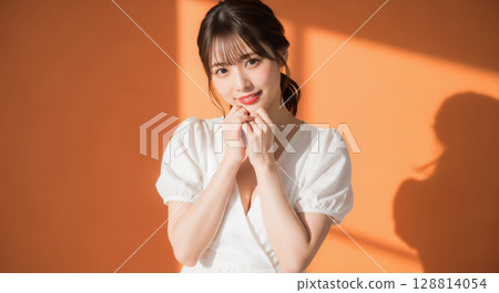 Natural smiling young woman portrait on orange background 128814054