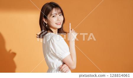 橙色背景中自然微笑的年輕女子肖像 128814061