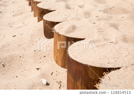 Wooden Border Partially Covered with Sand on a Sunny Beach Wooden Border Partially Covered with Sand on a Sunny Beach 128814513