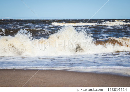 Powerful Sea Wave Crashing onto Shoreline During Windy Day on the Coast Powerful Sea Wave Crashing onto Shoreline During Windy Day on the Coast 128814514
