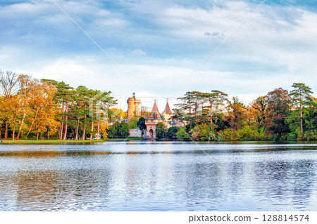 Autumn Laxenburg park with medieval Franzensburg castle in distance by blue sky in Austria 128814574