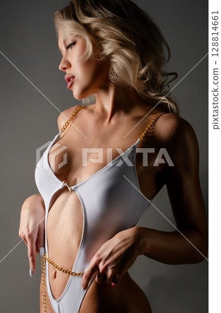 Woman performing a striking dance pose in lingerie during a studio session 128814661