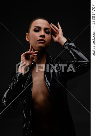 Captivating beauty in striking black attire against a dark background Captivating beauty in striking black attire against a dark background 128814707