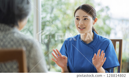 A female caregiver explaining to her family 128814802
