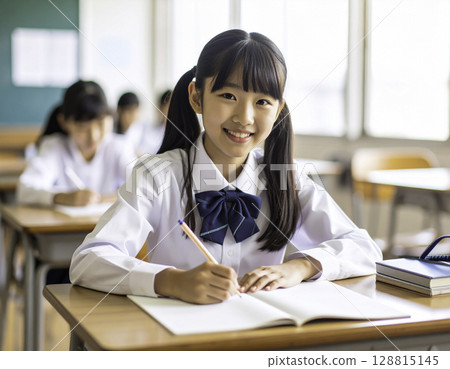 Smiling female student (Japanese) working on her notebook: Study time in a bright classroom 128815145