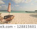 A solitary umbrella and wicker chairs facing the vast sea on a sunny summer day on the island of Koh Rong Sanloem, Sihanoukville, Cambodia 128815601