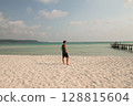 A man stands on a sandy beach looking out at the calm ocean in Koh Rong Sanloem, Sihanoukville, Cambodia 128815604