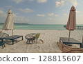 A serene beach setting with umbrellas, lounge chairs, and calm sea under a cloudy sky in Koh Rong Sanloem, Sihanoukville, Cambodia 128815607