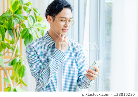 在辦公室裡操作智能手機的中年商人 128816250