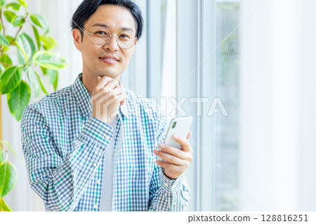 在辦公室裡操作智能手機的中年商人 128816251