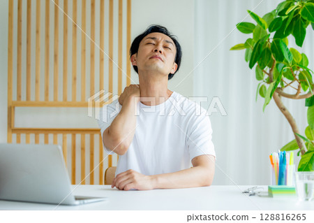 一名男子在使用筆記型電腦時抱著頭 128816265