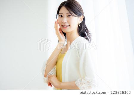 A woman who puts her hand on her cheek 128816303