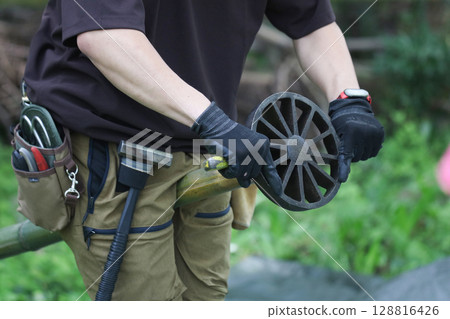 一名男子用劈竹器劈竹子 一名男子用劈竹器劈竹子 128816426