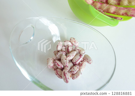Pink kidney bean pods and beans in glass bowl on kitchen table. Healthy food and vegetables. Organic seasonal farm products. 128816881