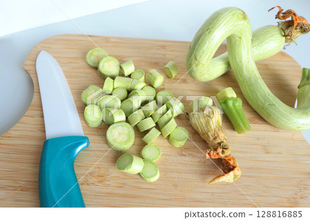 Zucchini sliced into unusual shapes on cutting board with ceramic knife. Healthy food and vegetables. Organic seasonal farm products. 128816885