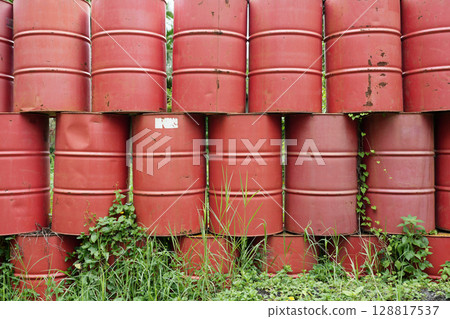 Red barrels lines up in green grass field Red barrels lines up in green grass field 128817537