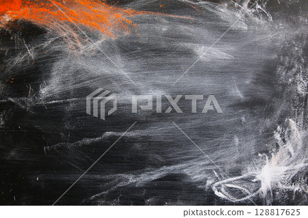 Blackboard with white chalk smudges scattered over its dark surface 128817625