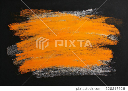 Blackboard marked with orange and white chalk smudges on dark background Blackboard marked with orange and white chalk smudges on dark background 128817626