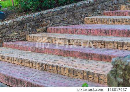 Rising staircase of the street sidewalk, paved with paving slabs, is empty, deserted. An empty space for design, blank for an artistic work, a symbolic sign - an increase in the level of development 128817687