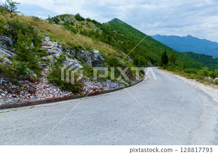 Mountain road winding through green hills Mountain road winding through green hills 128817793