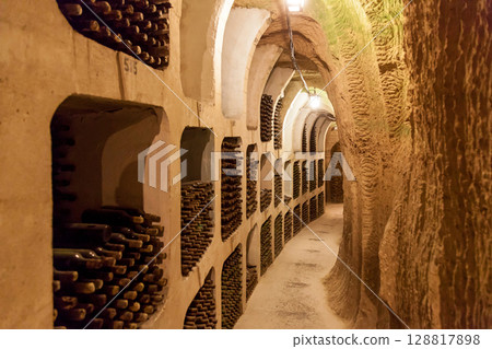 Wine cellar tunnel with aged bottles stored in stone niches 128817898