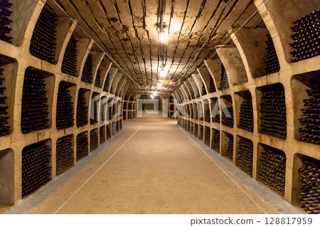 Endless underground wine cellar tunnel with dusty aged bottles Endless underground wine cellar tunnel with dusty aged bottles 128817959