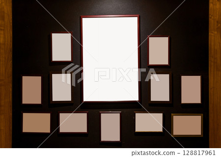 Empty wooden frames on dark wall background 128817961