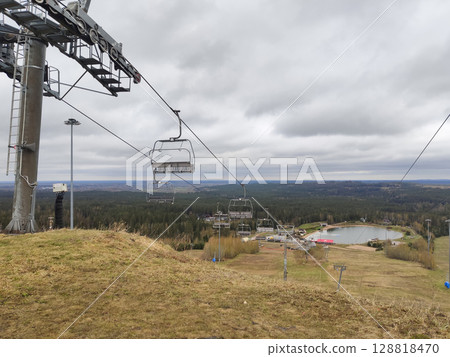 A ski lift at a ski resort in cloudy weather. A spring landscape photo at the Igora resort, Leningrad region. 2024. 128818470