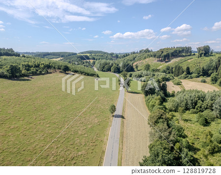 Thommen, Liege, Belgium, A picturesque rural road that is beautifully surrounded by lush green 128819728