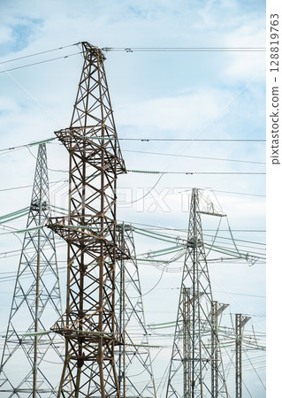 High voltage electrical power lines and transmission towers create a network for electric energy supply and industrial use. 128819763