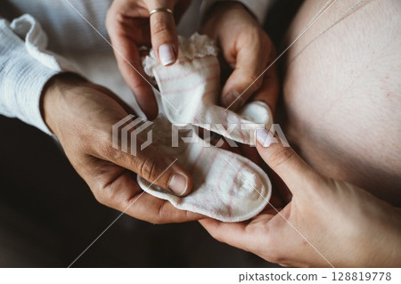 Expectant Parents Holding Baby Socks with Tenderness 128819778