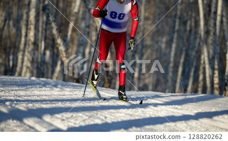 skier goes classic style in birch forest at ski racing competition 128820262