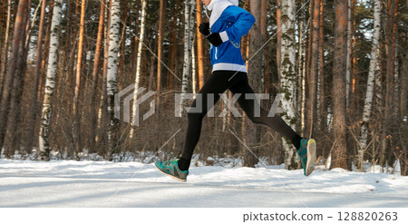 male runner athlete in winter race or marathon on snow-covered trail 128820263