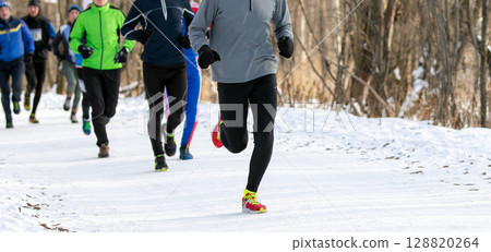 group runners athletes in winter race or marathon on snow-covered trail 128820264