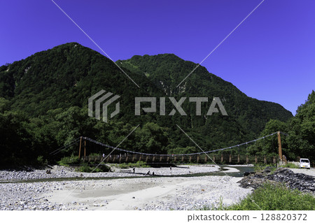 橫跨清澈溪流和鬱鬱蔥蔥的山巒的明神橋的夏季風景 橫跨清澈溪流和鬱鬱蔥蔥的山巒的明神橋的夏季風景 128820372