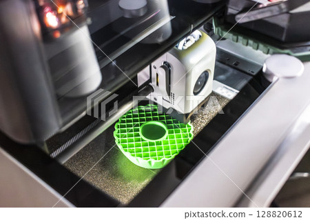 3d printer printing an object on the tray with pla filament, corn starch, non-waterproof filament 3d printer printing an object on the tray with pla filament, corn starch, non-waterproof filament 128820612