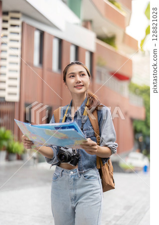 Young traveler reading map while exploring city streets Young traveler reading map while exploring city streets 128821028