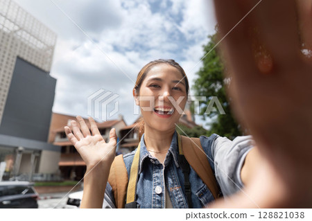 Young woman taking selfie outdoors, capturing joyful moment Young woman taking selfie outdoors, capturing joyful moment 128821038