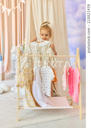 Little child girl choosing her clothes. Little child girl choosing her clothes. 128821439