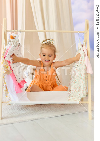 A little girl chooses what clothes to wear A little girl chooses what clothes to wear 128821443