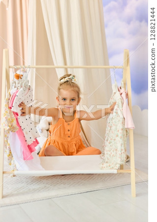 A little girl chooses what clothes to wear 128821444